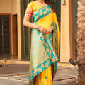 Yellow Silk Saree with Teal Green Contrast Border Floral Zari Work