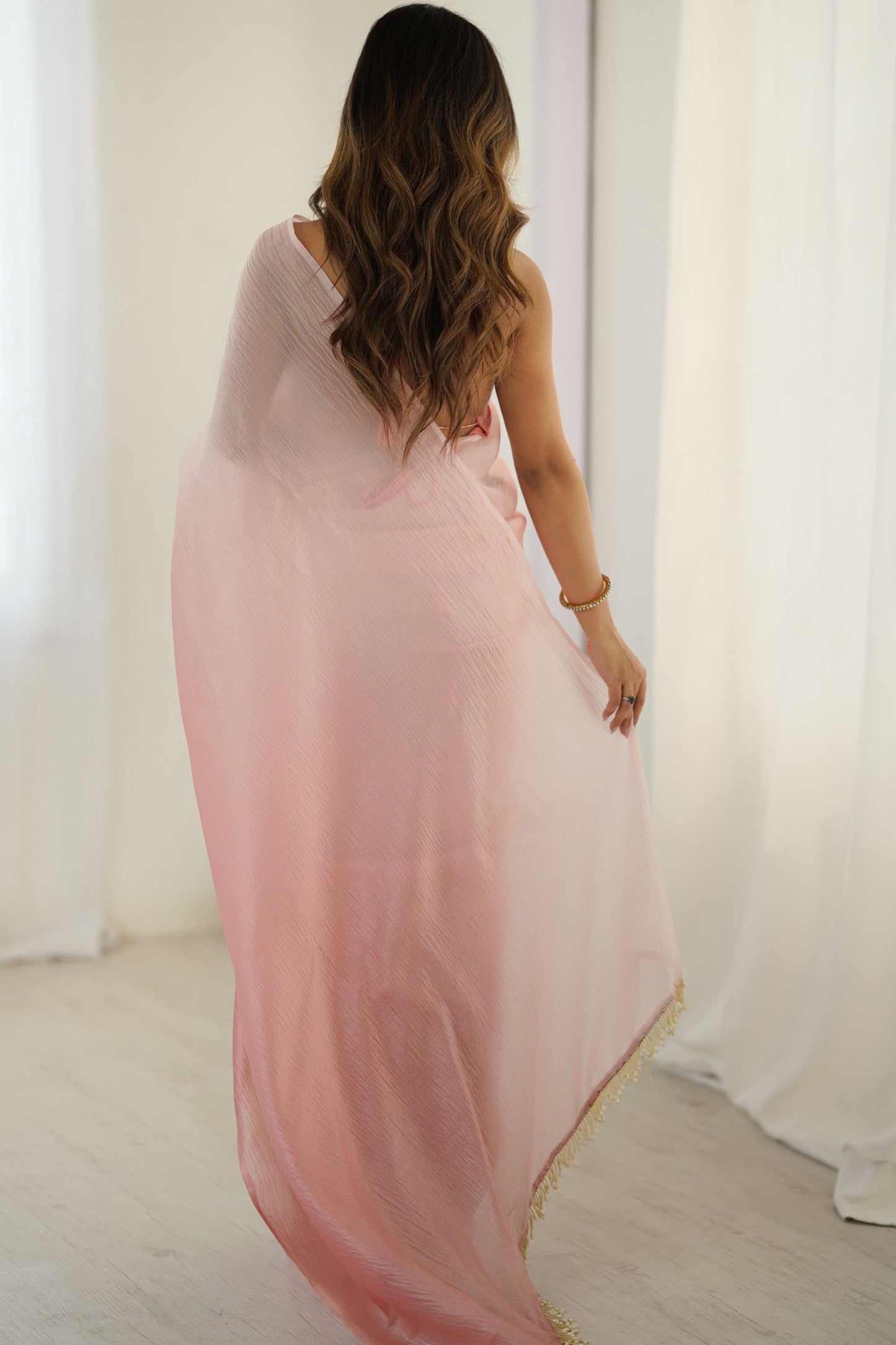 Elegant Peach Organza Saree with Minimal Texture Tassel Border