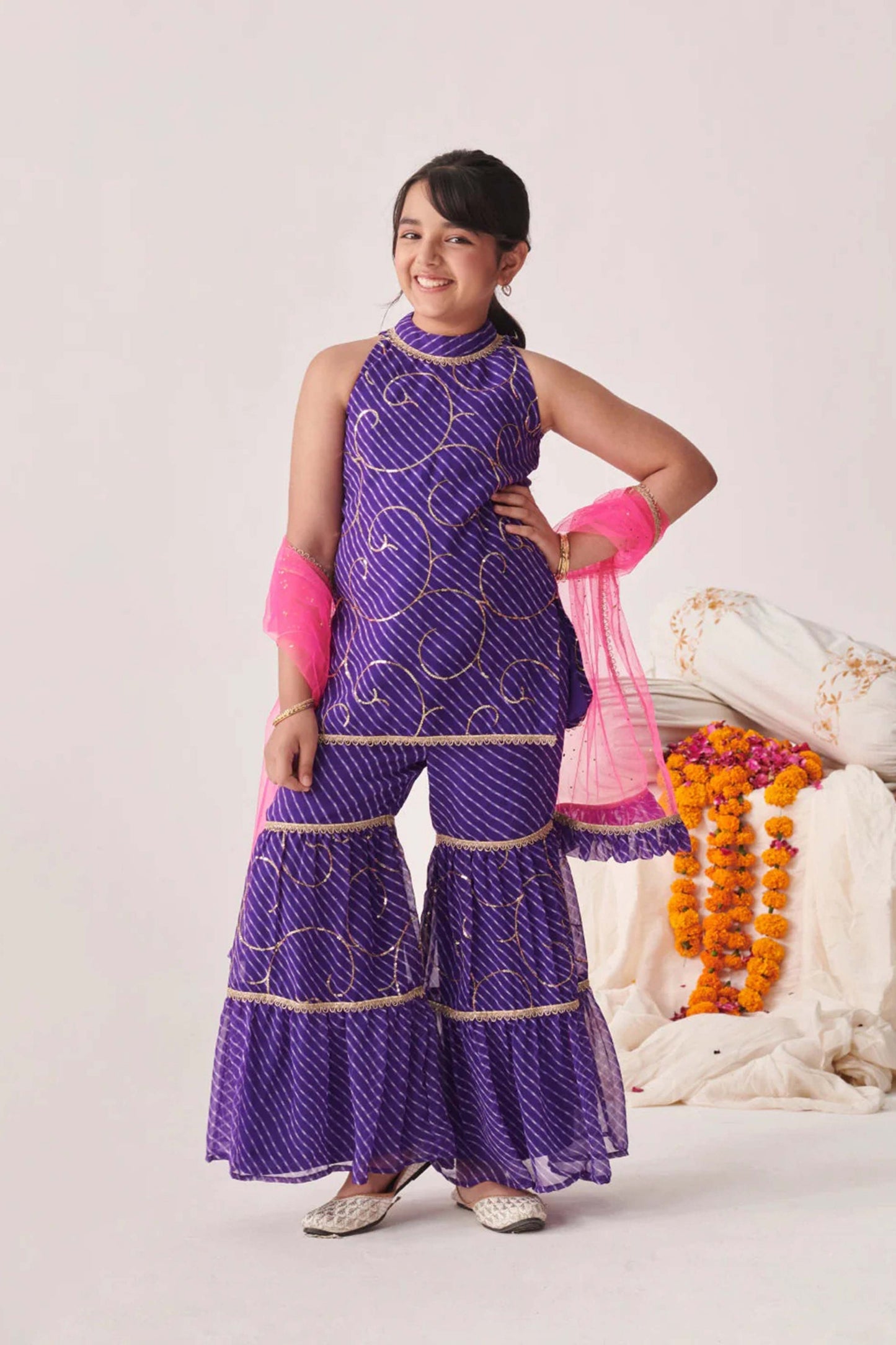 Young girl wearing trendy purple printed sharara set with pink dupatta